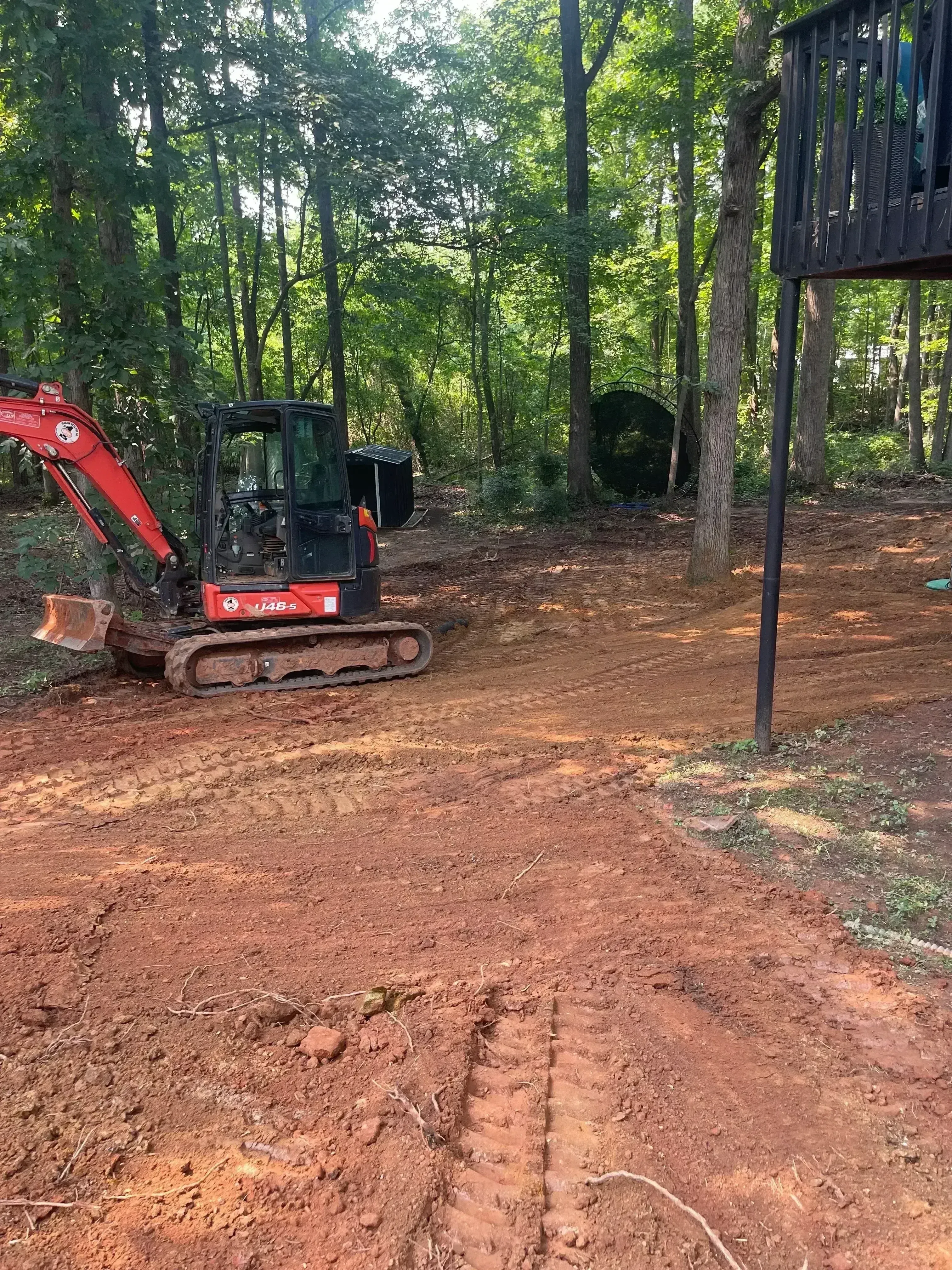 Red clay excavation site with installed septic tank and wooden access frame structures