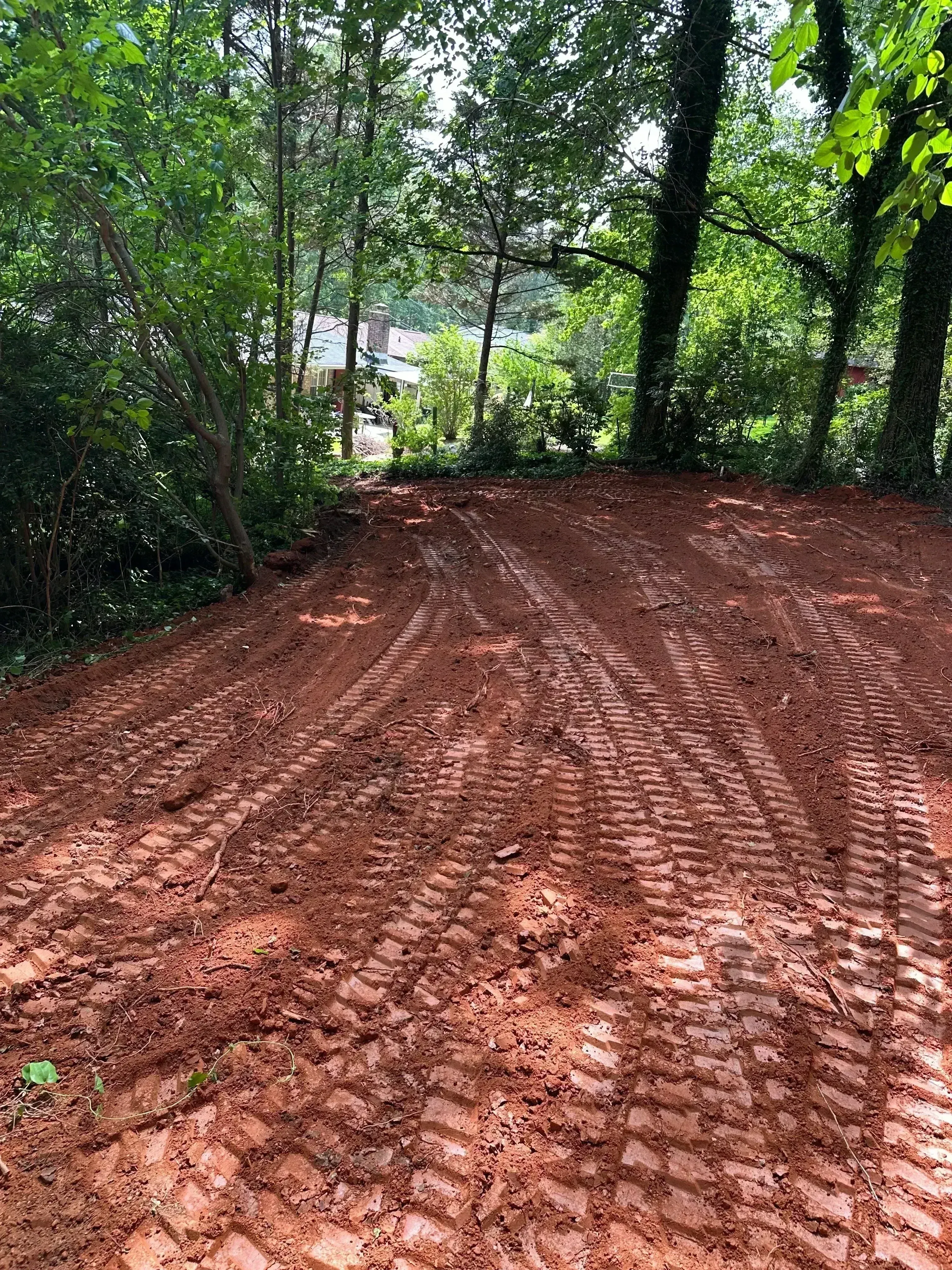 Excavated septic drain field with red clay soil and graded trenches for system installation